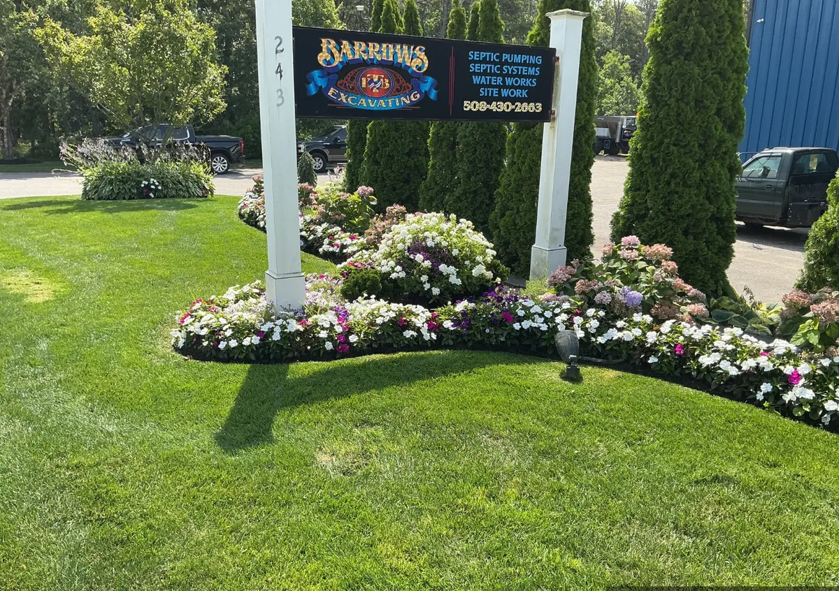 Curved annual bed in full bloom along a tidy lawn at a Harwich MA commercial property